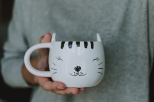 : A close-up of a mug with a drawing of a cat, commonly seen in the world of cat cafes